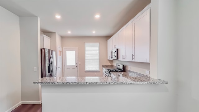 kitchen with white cabinetry, light stone counters, kitchen peninsula, and appliances with stainless steel finishes