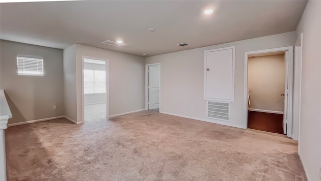 unfurnished bedroom featuring light carpet and a spacious closet