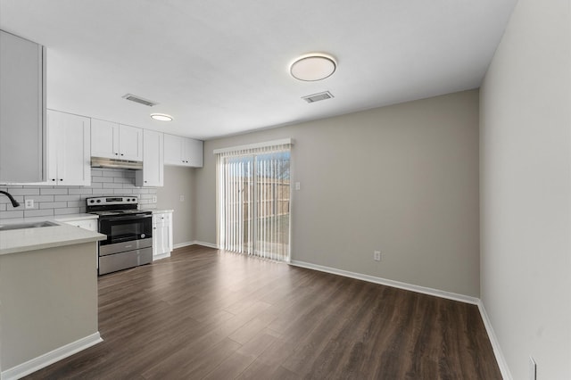 kitchen featuring sink, backsplash, electric range, dark hardwood / wood-style floors, and white cabinets