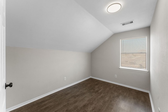 additional living space with dark hardwood / wood-style floors and vaulted ceiling