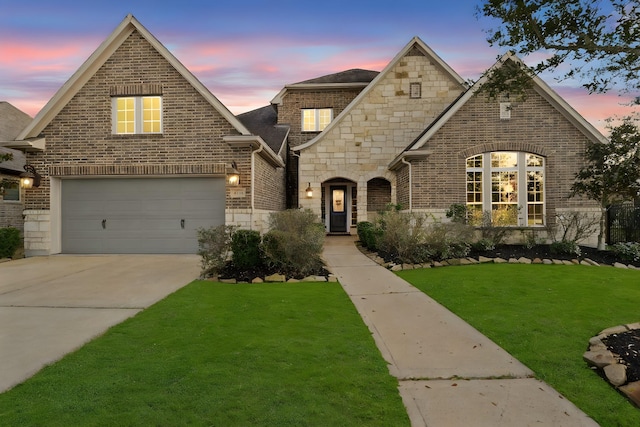 view of front of property featuring a yard and a garage