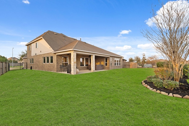 rear view of house featuring a yard and a patio