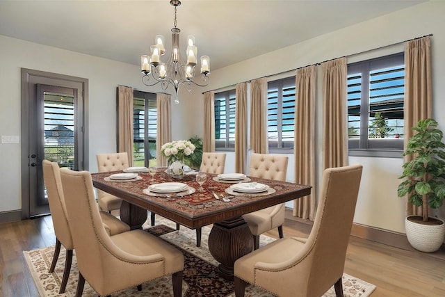 dining space with a notable chandelier and hardwood / wood-style flooring