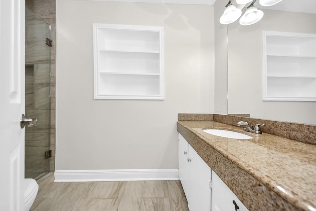 bathroom with vanity, built in features, toilet, and walk in shower