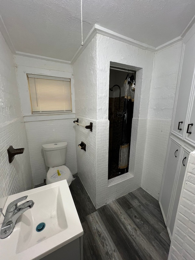 bathroom with hardwood / wood-style flooring, crown molding, a textured ceiling, and toilet