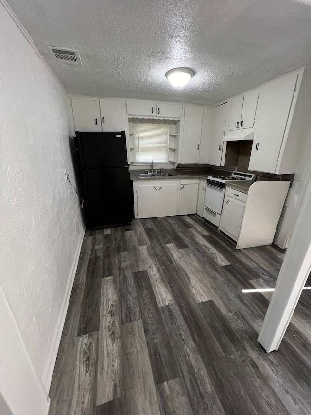 kitchen with black refrigerator, sink, white cabinets, gas range gas stove, and dark wood-type flooring