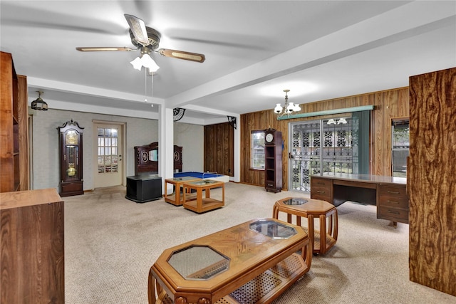 living area with wood walls, beamed ceiling, carpet floors, and ceiling fan with notable chandelier