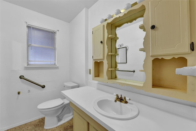 bathroom featuring toilet, vanity, and baseboards