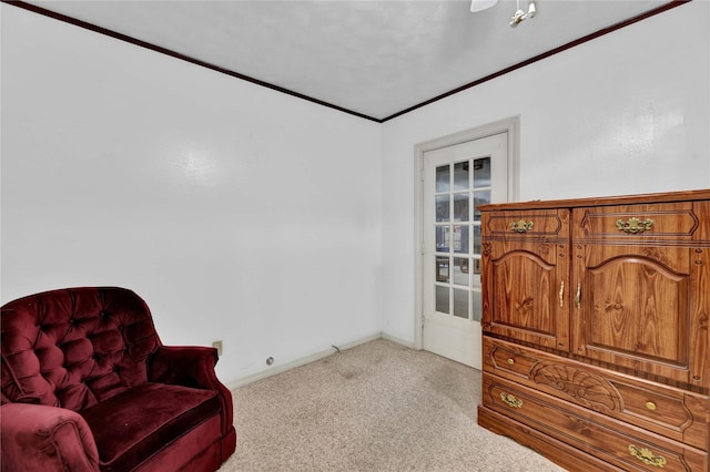 living area with carpet flooring, crown molding, and baseboards