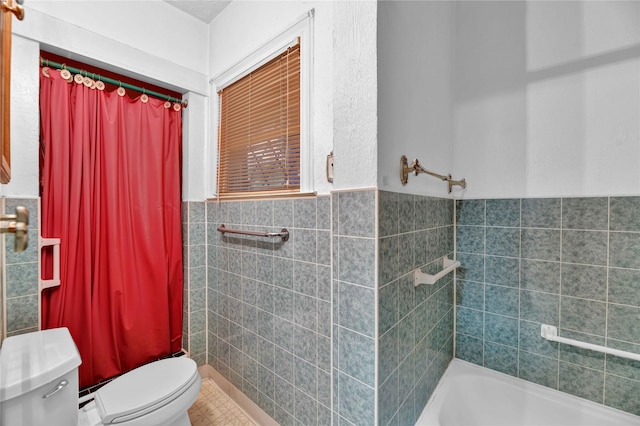 full bath with toilet, tile walls, and a wainscoted wall
