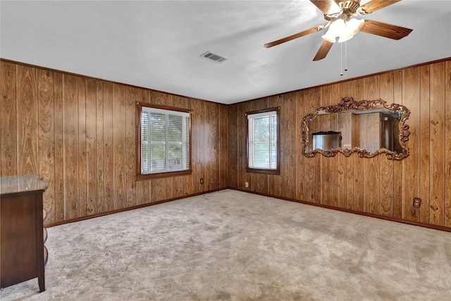 empty room featuring visible vents, ceiling fan, light carpet, and baseboards