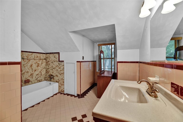 full bath with tile walls, lofted ceiling, a bath, vanity, and tile patterned floors