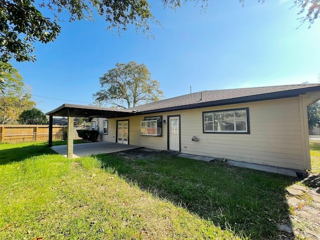 rear view of property with a patio and a lawn