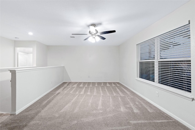 empty room featuring ceiling fan and light carpet