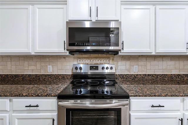 kitchen featuring dark stone countertops, white cabinets, and appliances with stainless steel finishes