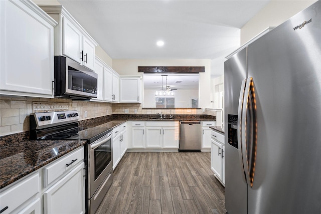 kitchen featuring sink, white cabinetry, tasteful backsplash, decorative light fixtures, and stainless steel appliances