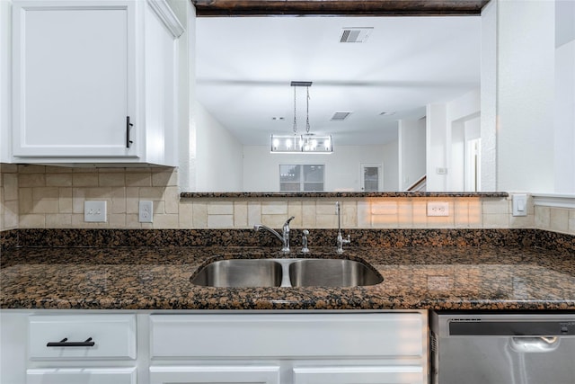 kitchen featuring decorative light fixtures, sink, dark stone countertops, white cabinets, and stainless steel dishwasher