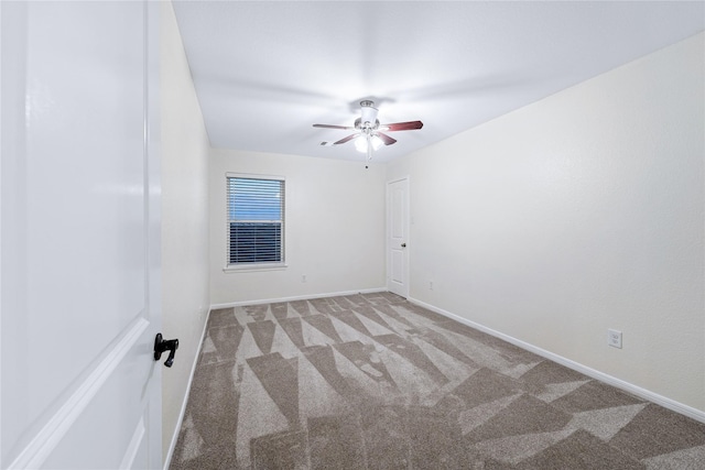 spare room with ceiling fan and carpet