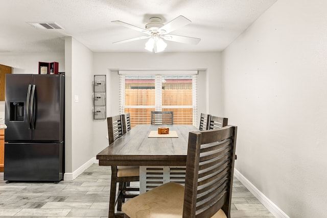 dining area with a textured ceiling and ceiling fan