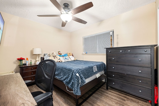 bedroom featuring ceiling fan, dark hardwood / wood-style floors, and a textured ceiling