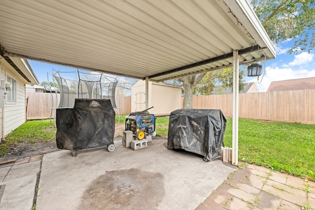 view of patio featuring area for grilling, a trampoline, and a shed