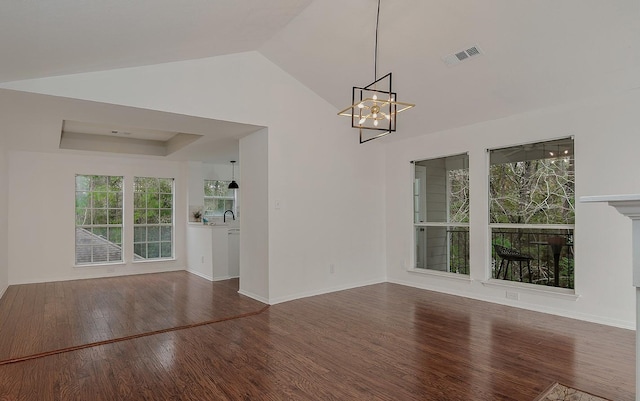 interior space with dark hardwood / wood-style flooring, sink, a notable chandelier, and vaulted ceiling