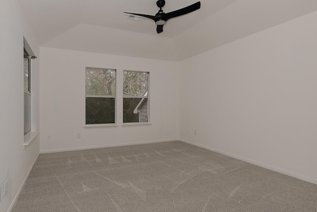 carpeted spare room featuring a tray ceiling and ceiling fan