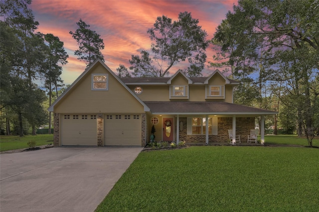 view of front facade featuring a garage, a yard, and covered porch