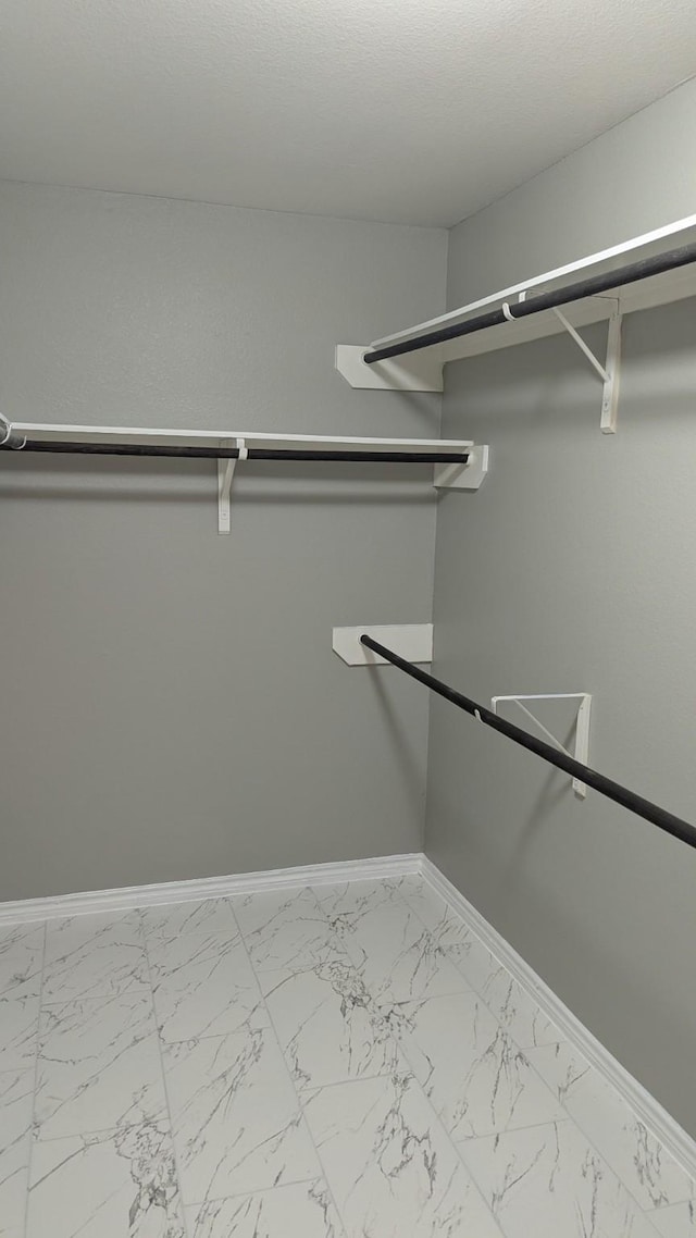 spacious closet featuring marble finish floor