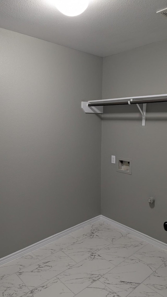 laundry area featuring marble finish floor, laundry area, and baseboards