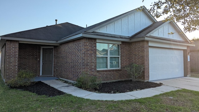 single story home featuring a garage, driveway, brick siding, and board and batten siding