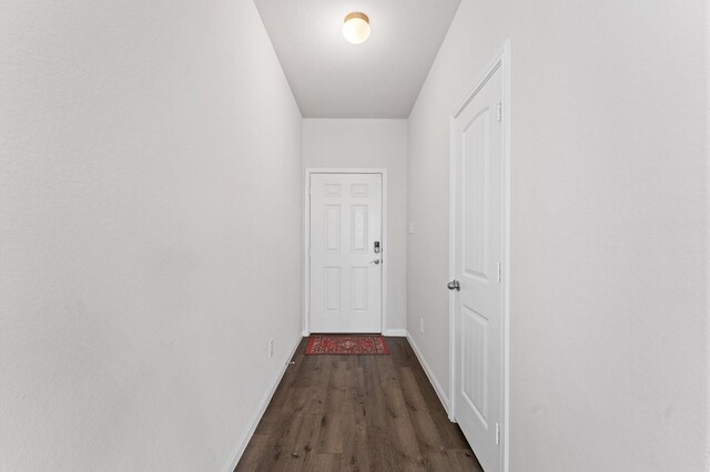 hallway featuring dark wood-style floors and baseboards