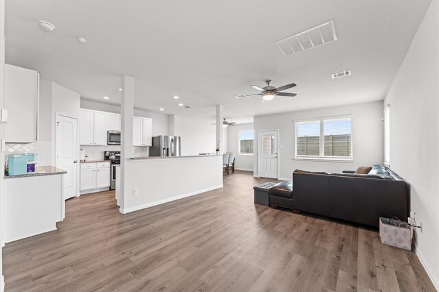 living room featuring light wood-style flooring, visible vents, ceiling fan, and recessed lighting