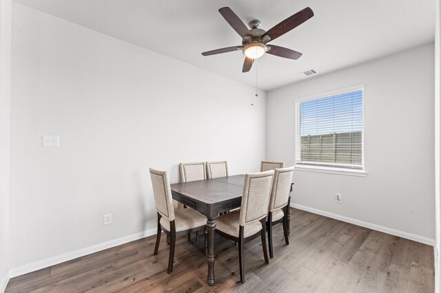 dining space featuring ceiling fan, wood finished floors, visible vents, and baseboards