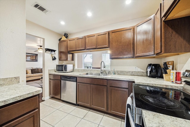 kitchen with light tile patterned floors, visible vents, appliances with stainless steel finishes, a ceiling fan, and a sink