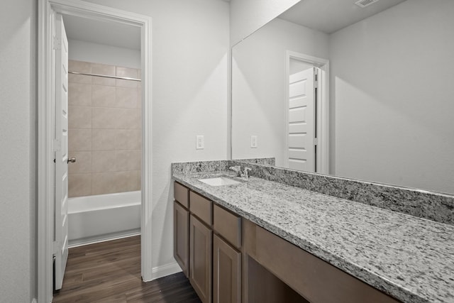 bathroom featuring shower / bathtub combination, wood finished floors, and vanity