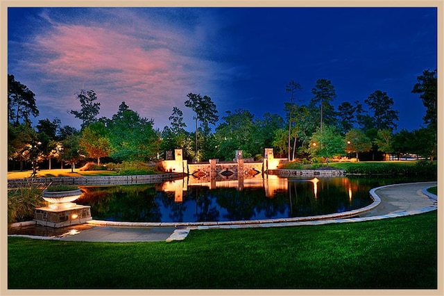 view of home's community with a water view and a yard