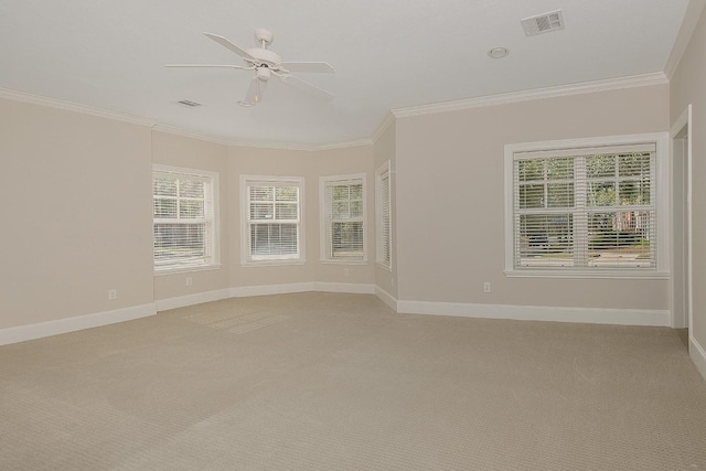 carpeted spare room with crown molding, ceiling fan, and a healthy amount of sunlight