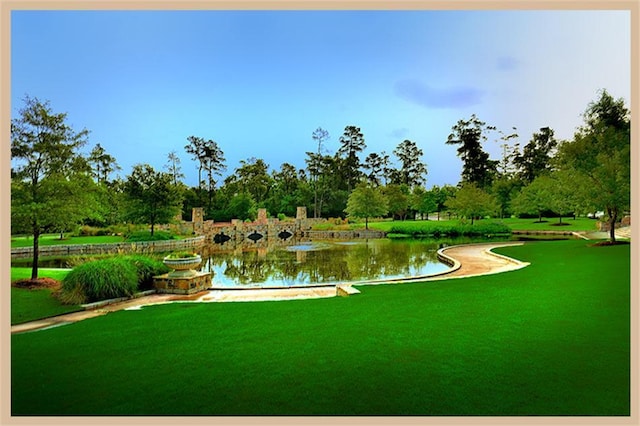 view of community with a lawn and a water view