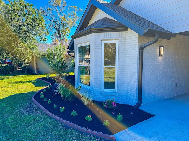 view of side of home with a yard