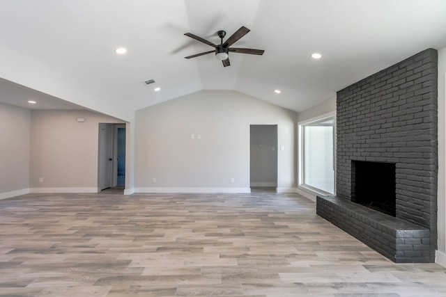 unfurnished living room with a brick fireplace, vaulted ceiling, ceiling fan, and light wood-type flooring