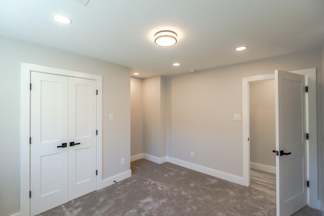 unfurnished bedroom featuring a closet and dark colored carpet