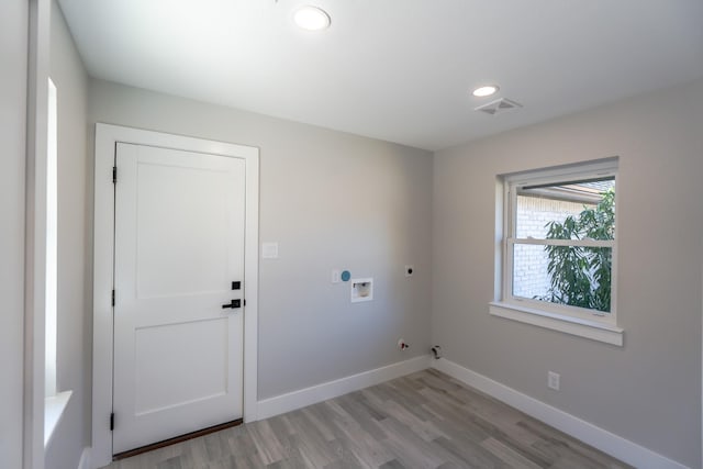 washroom with hookup for a washing machine, gas dryer hookup, hookup for an electric dryer, and light wood-type flooring