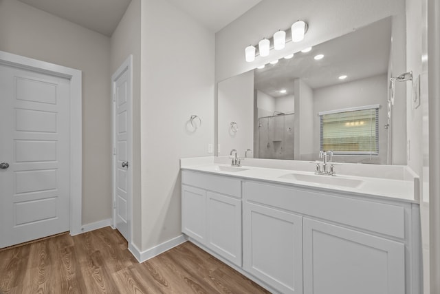 bathroom featuring walk in shower, vanity, and hardwood / wood-style floors