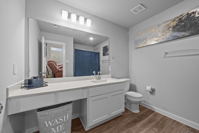 bathroom with vanity, wood-type flooring, and toilet