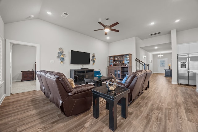 living room with hardwood / wood-style floors, vaulted ceiling, and ceiling fan