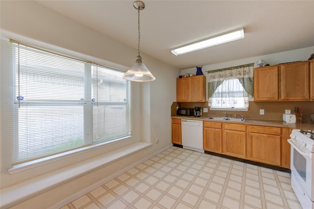 kitchen featuring sink, white appliances, and decorative light fixtures