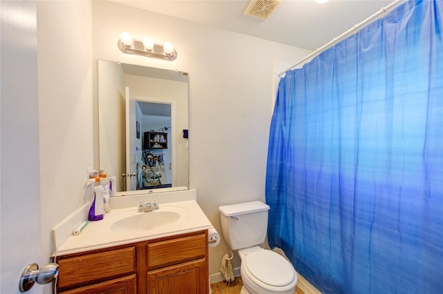 bathroom with vanity, curtained shower, and toilet