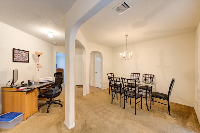 dining space with light colored carpet, a chandelier, and a textured ceiling