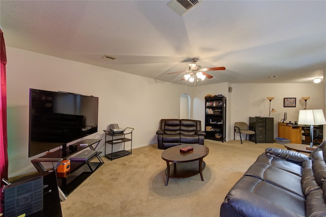 carpeted living room with ceiling fan and a textured ceiling